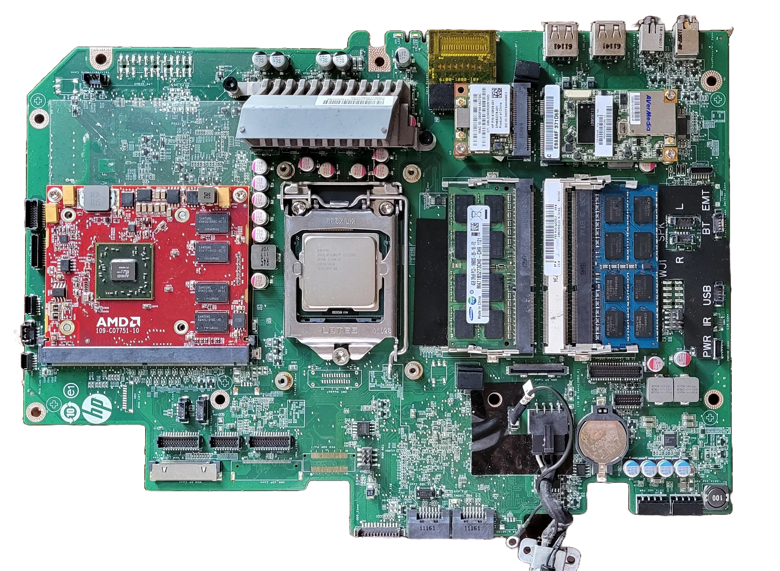Top view of the ~25x20 cm flat green desktop computer's motherboard, featuring (right to left) two memory chips, a cpu chip, and a graphics card.